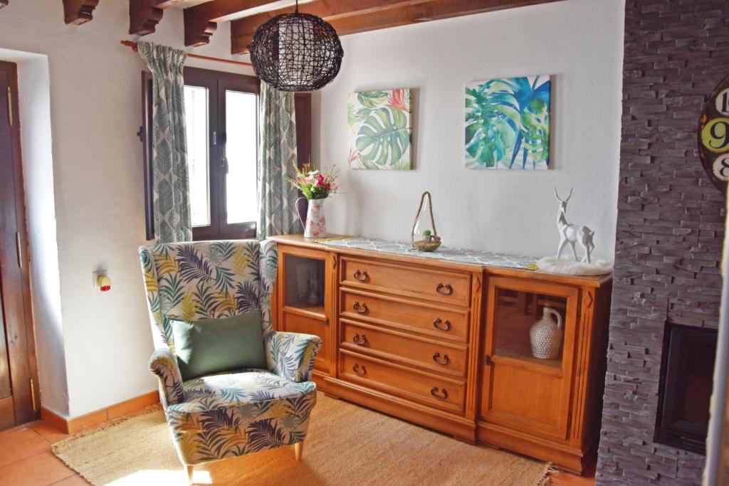 sala de estar con cómoda y silla en Casa El Simancón en Grazalema