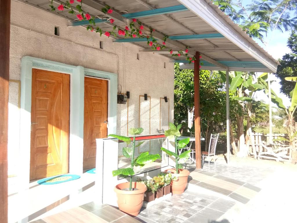 a porch with potted plants on a house at RoomStay Tok Abah A in Kuala Rompin