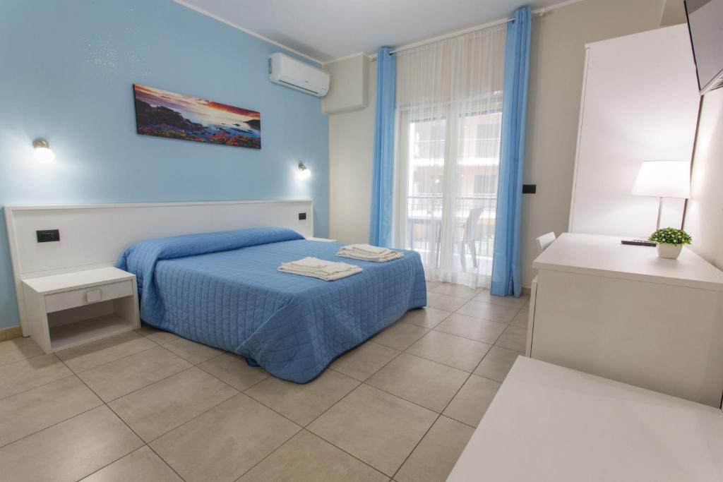 ein blaues Schlafzimmer mit einem Bett und einem Fenster in der Unterkunft I Granai Messina in Messina