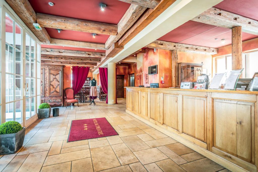 Cette grande chambre dispose d'un bar avec des placards en bois. dans l'établissement Hôtel Du Théâtre Centre Historique Parking Gratuit, à Metz