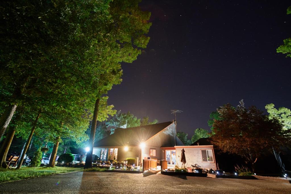 Una casa de noche con las luces encendidas en Williamsburg Camping Resort One Bedroom Cabin 6, en Croaker