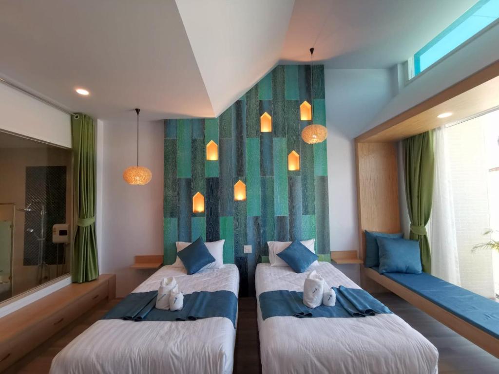 Duas camas num quarto com cortinas verdes e candeeiros em เดอะชาลี The Charlie em Nan