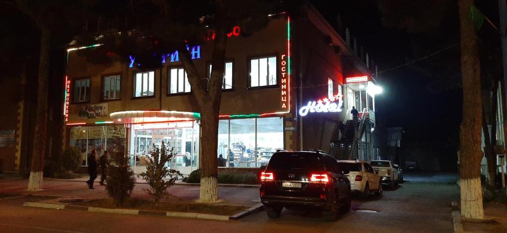 un coche aparcado delante de un edificio por la noche en Umariyon, en Panjakent