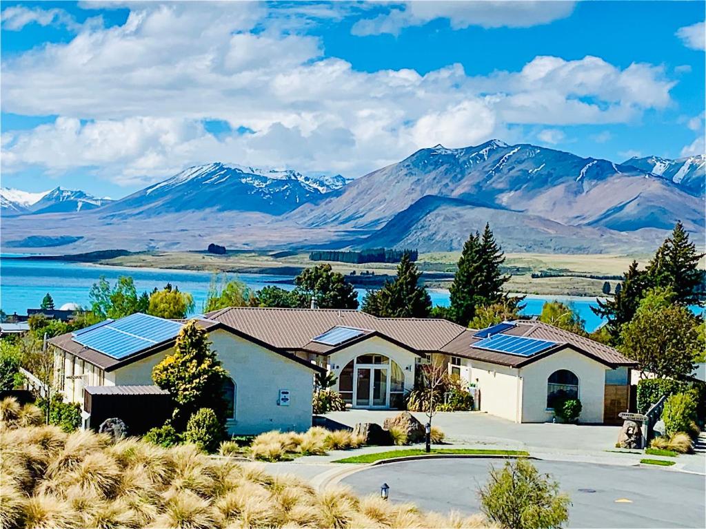 a house with solar panels in front of mountains at Tekapo Heights in Lake Tekapo