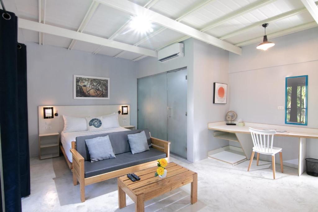 a bedroom with a bed and a desk and a table at Reef Beach Resort in General Luna