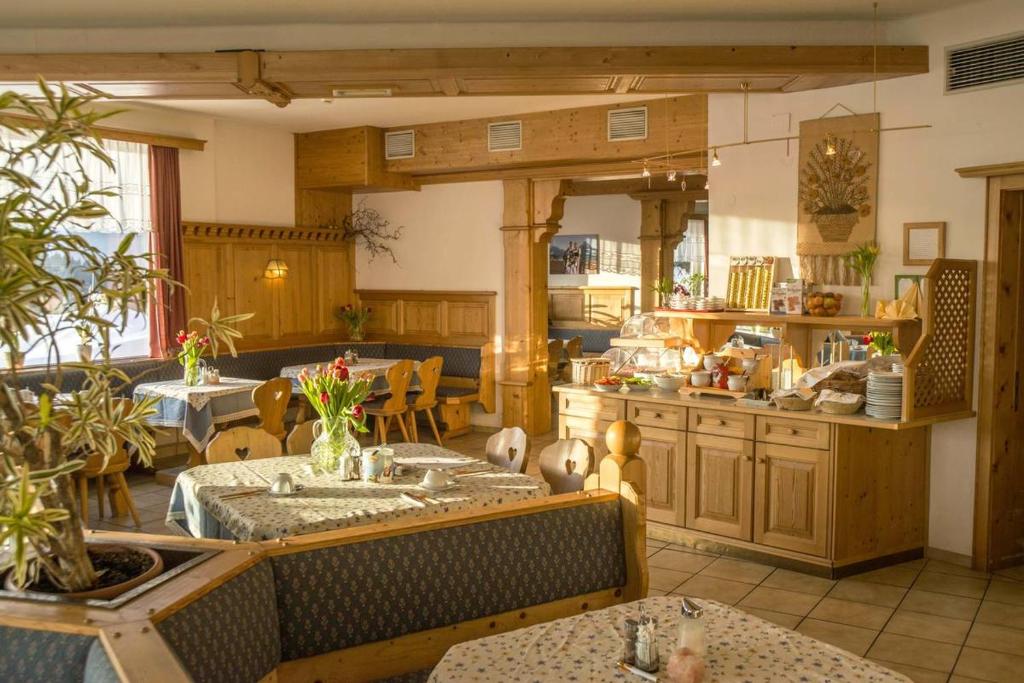 a kitchen with tables and chairs in a room at Hotel Pension Sonnenuhr in Tauplitz