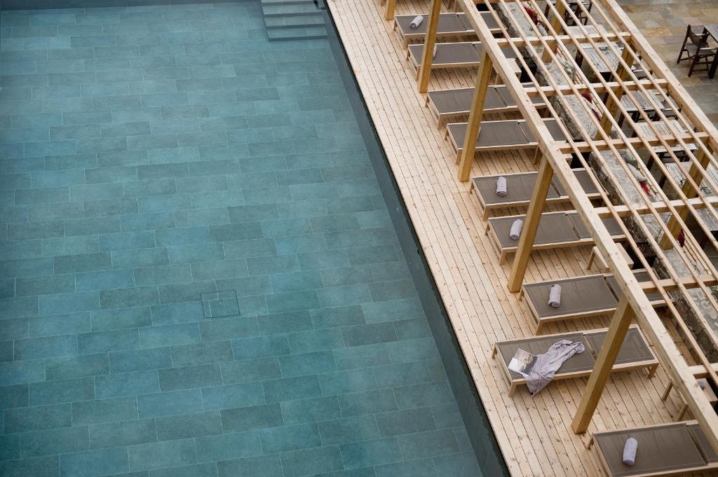 an overhead view of a swimming pool with a ladder at Hotel Schwarzschmied in Lana