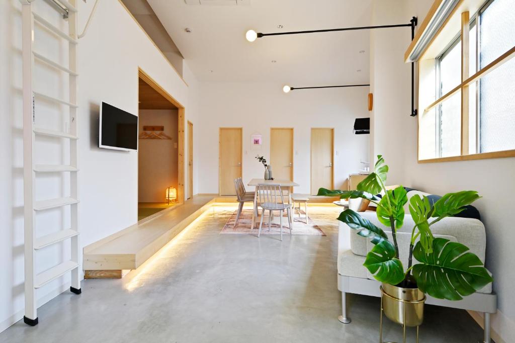 a living room with a couch and a table at nid Osaka Tenma in Osaka