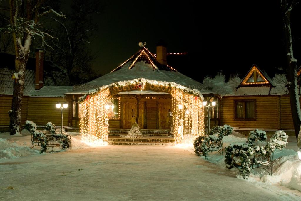 a house covered in christmas lights in the snow at ООО РГК Русская охота in Penza