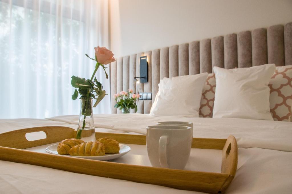 a tray with a plate of food on a bed at Verde Apartments CENTRUM in Koszalin