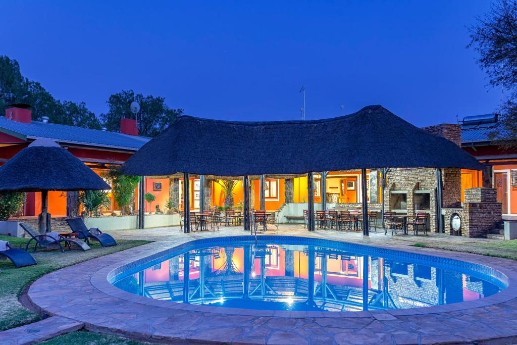 a house with a swimming pool with a gazebo at Auas Safari Lodge in Windhoek