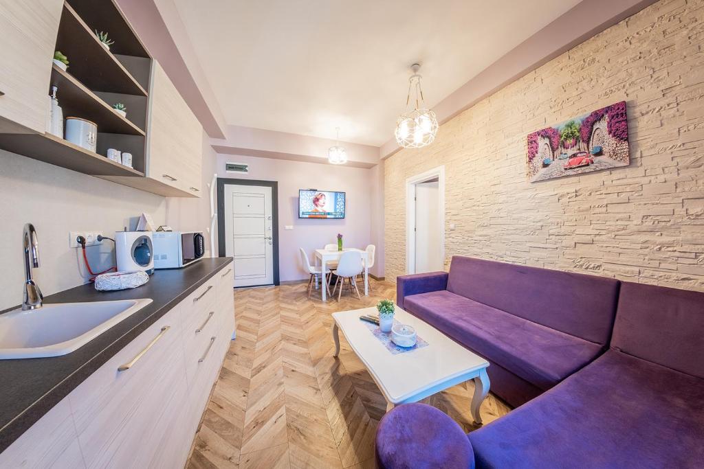 sala de estar con sofá púrpura y mesa en Sofia Violet Life Apartment en Sofía