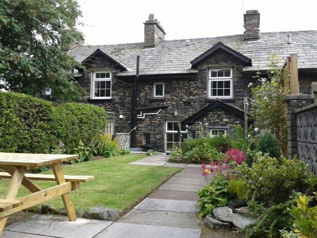 uma casa de pedra com uma mesa de piquenique em frente em Millcroft em Penrith