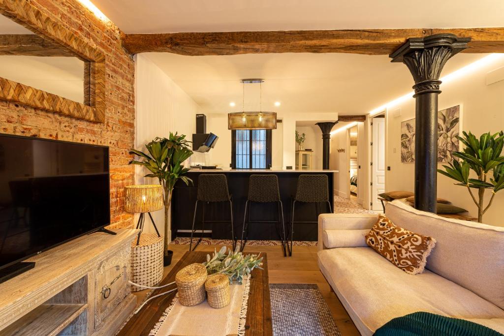 a living room with a couch and a tv at Bilbao la vieja alojamiento de diseño in Bilbao