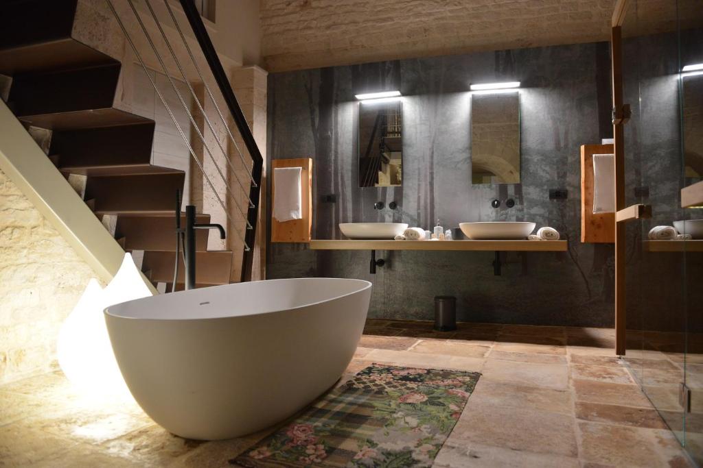 a large bathroom with two sinks and a tub at Gatto Bianco Case d&#39;Allora in Alberobello
