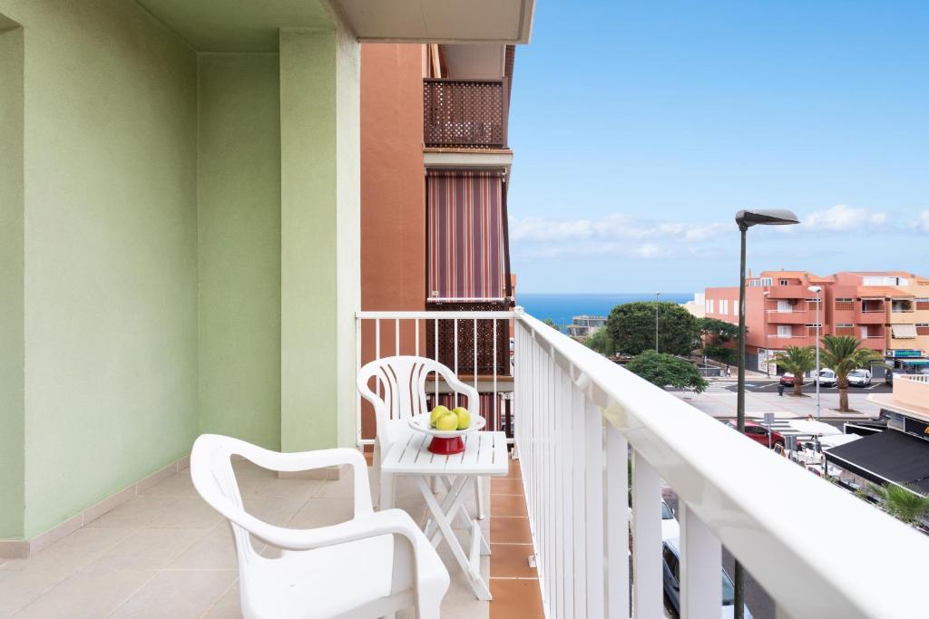 een balkon met 2 stoelen en uitzicht op de oceaan bij Home2Book Charming Apartment Candelaria, Wifi & Pool in Candelaria