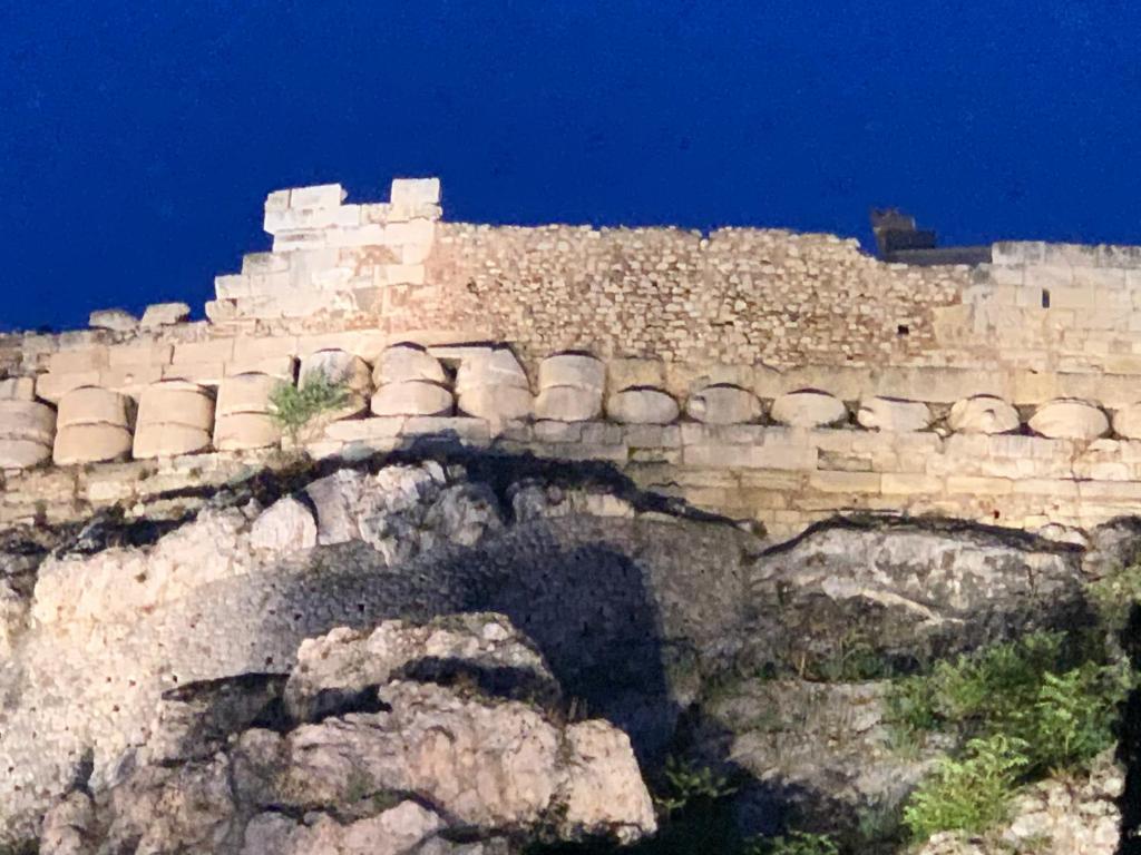 un mur en pierre avec des pots au sommet d'une montagne dans l'établissement At the Acropolis’ fence, à Athènes