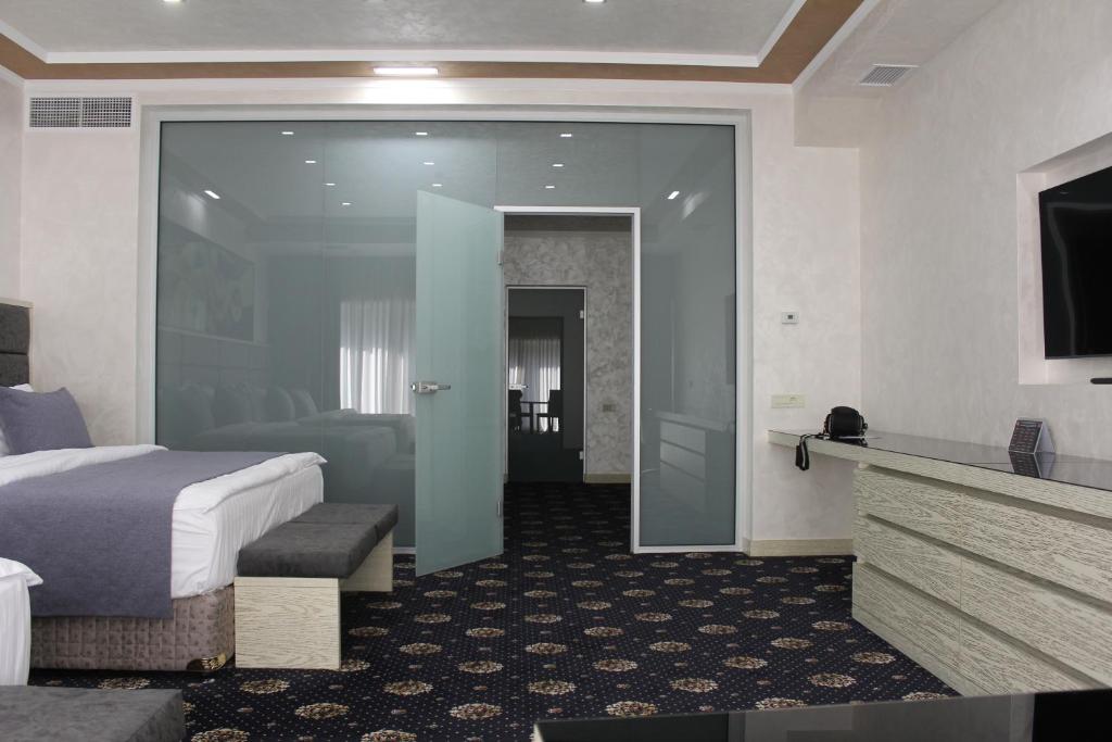 a bedroom with a bed and a dresser at Erebuni Hotel Yerevan in Yerevan