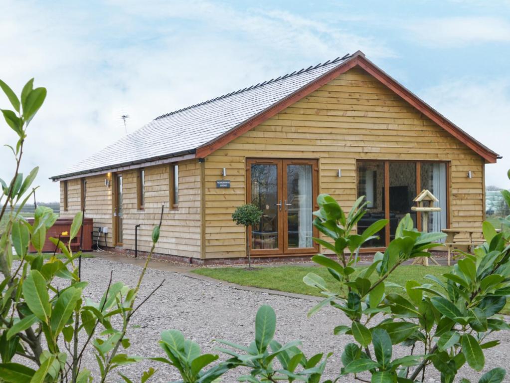 a log cabin with a large window at Woodman's Lodge in Nantwich