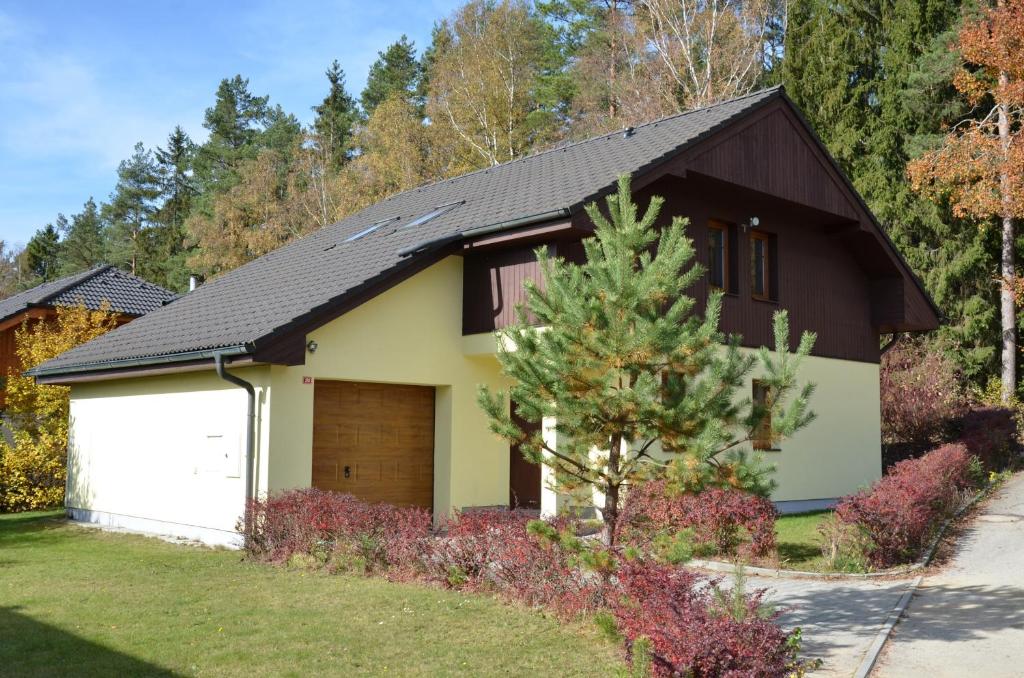 a house with a white garage and a brown roof at Holiday Villa Lipno Lake in Lipno nad Vltavou