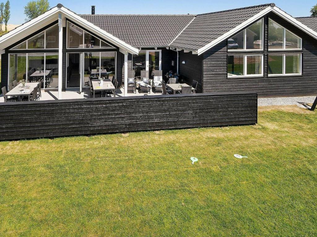 a house with a large deck with tables and chairs at 16 person holiday home in Hasselberg in Kappeln