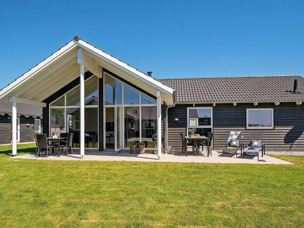 a house with a large screened porch with tables and chairs at 12 person holiday home in Hasselberg in Kappeln