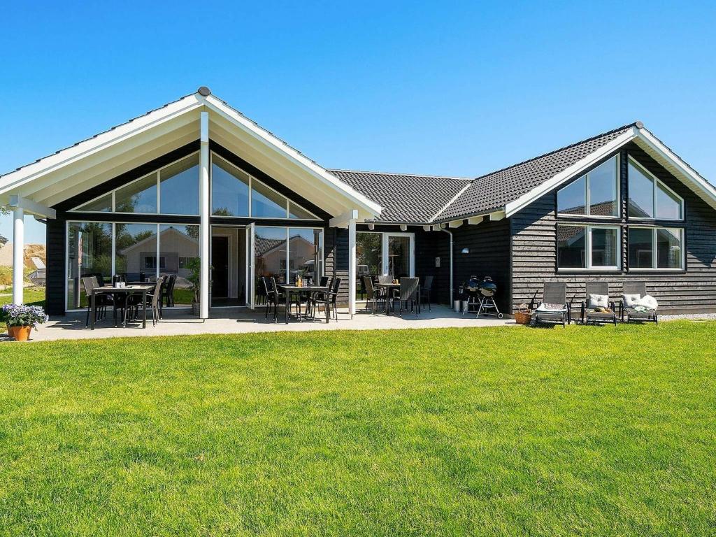 a house with large windows and green grass at 16 person holiday home in Hasselberg in Kappeln