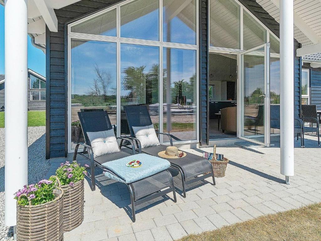 a patio with two chairs and a table and windows at 10 person holiday home in Hasselberg in Kappeln