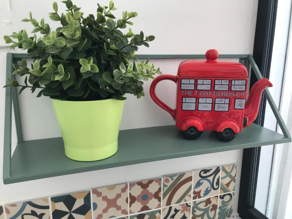 a green shelf with a red bus toy and a plant at Plan de Cuques T2 in Marseille