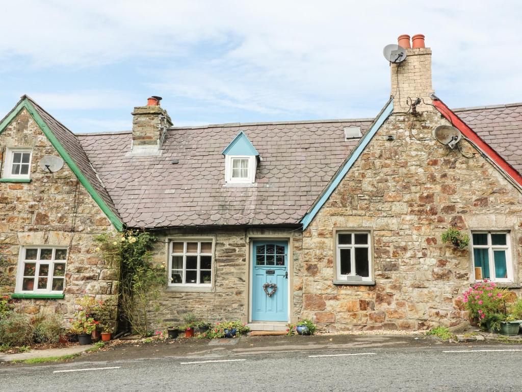 an old stone house with a blue door at Gerlan in Llandysul
