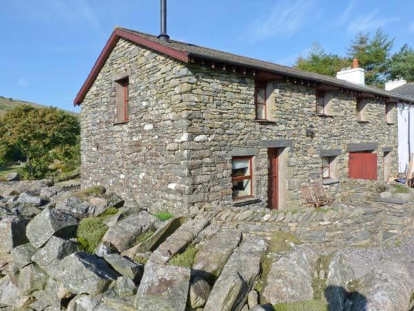 ein Steinhaus auf einer Felswand in der Unterkunft Copper Beech Cottage in Coniston