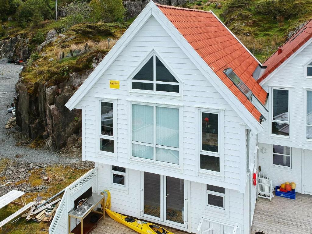 une maison blanche avec un toit orange dans l'établissement 6 person holiday home in Urangsv g, à Steinsbø