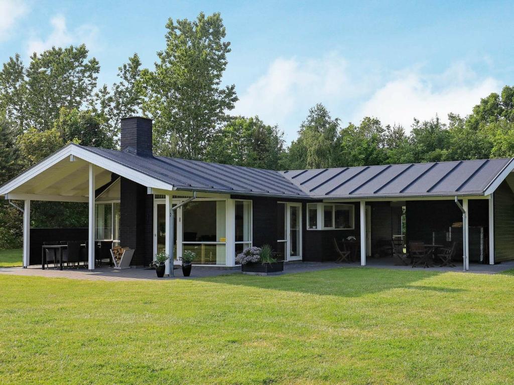 uma casa com um telhado de metal num quintal em 6 person holiday home in H jslev em Højslev