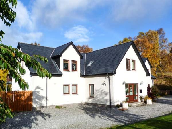 ein weißes Haus mit schwarzem Dach in der Unterkunft An Torr in Newtonmore