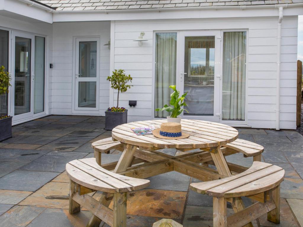 a wooden table and chairs on a patio at Hafod, Llangoed in Llangoed