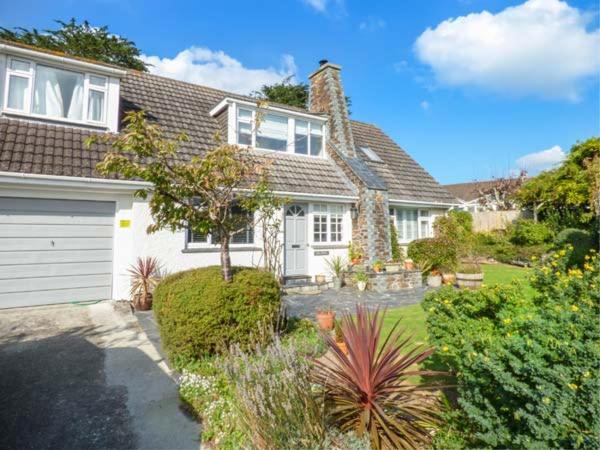 a large white house with a garage at Kilcarreg in Wadebridge