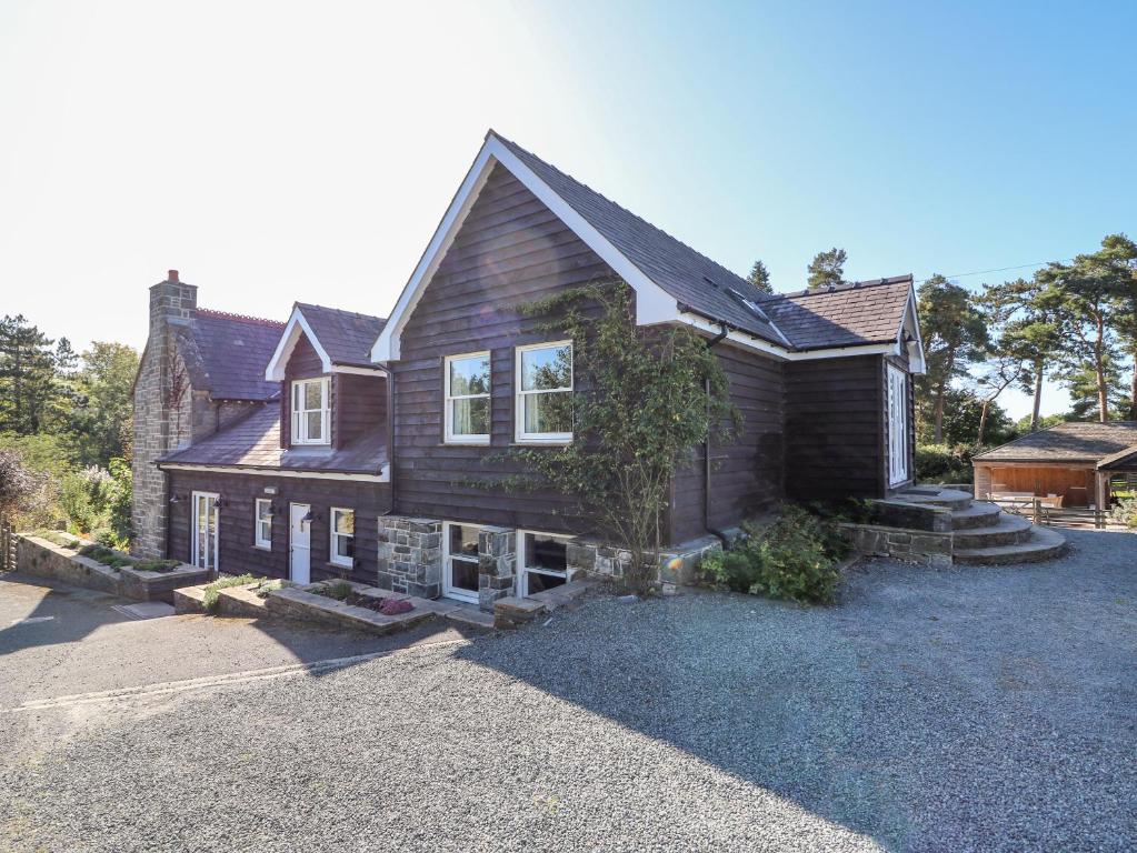 a large wooden house on a gravel driveway at The Pheasantry in Builth Wells