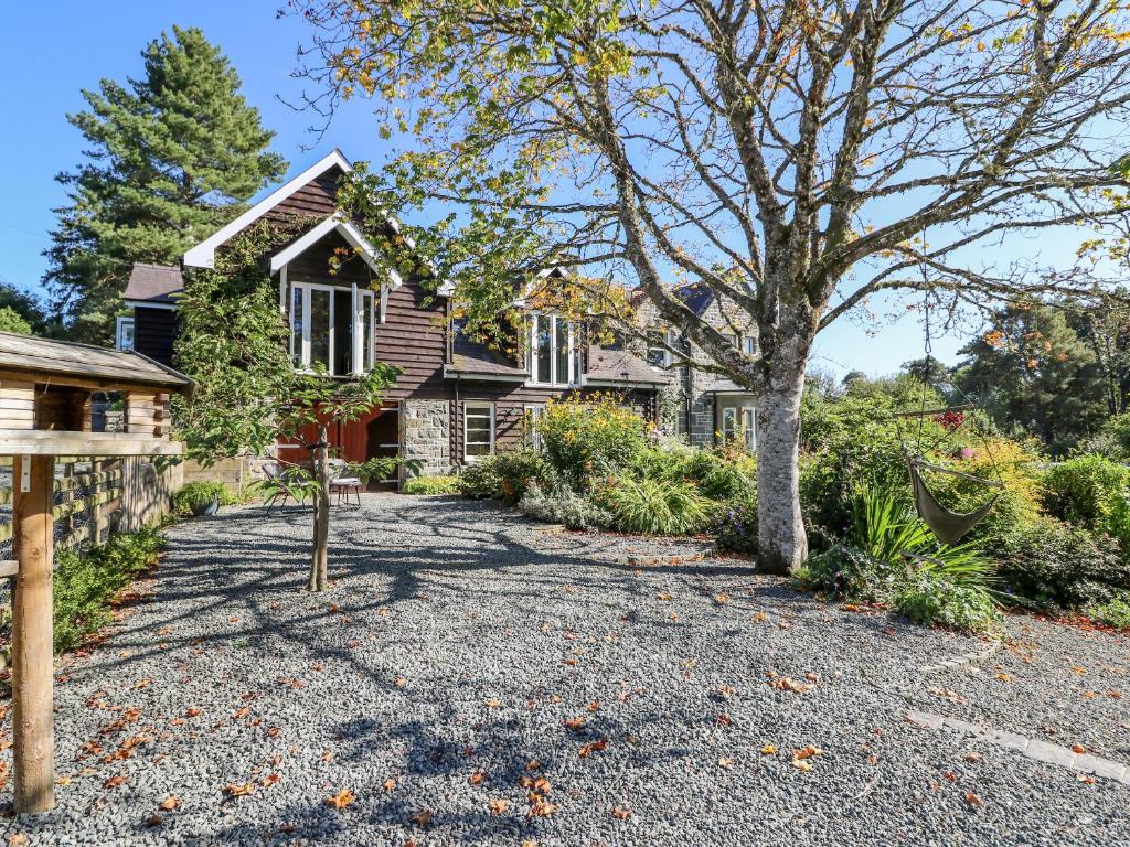 a house with a tree and a gravel driveway at The Pheasantry in Builth Wells