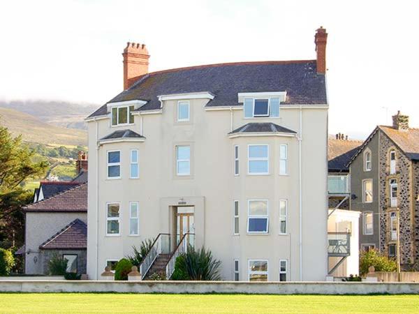 a large white house with a staircase in front at Gwylanedd One in Llanfairfechan