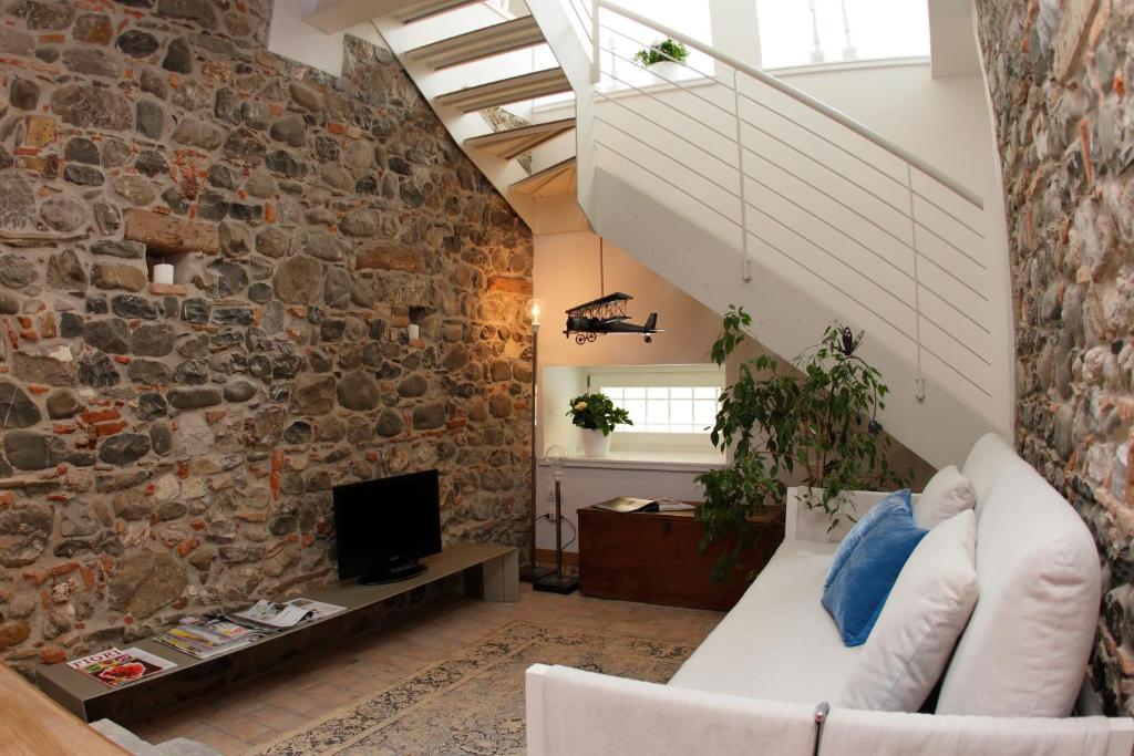 uma sala de estar com uma parede de pedra e um sofá em Casa Galante em Cividale del Friuli