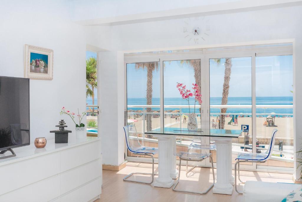 uma sala de jantar com uma mesa e vista para o oceano em Apartamento Lujo frente al Mar Centro de Malaga em Málaga