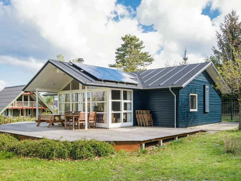 a blue house with a solar roof on a deck at 6 person holiday home in Glesborg in Glesborg