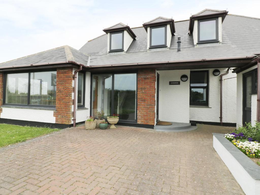 a house with a brick driveway in front of it at Chynoweth in Crantock