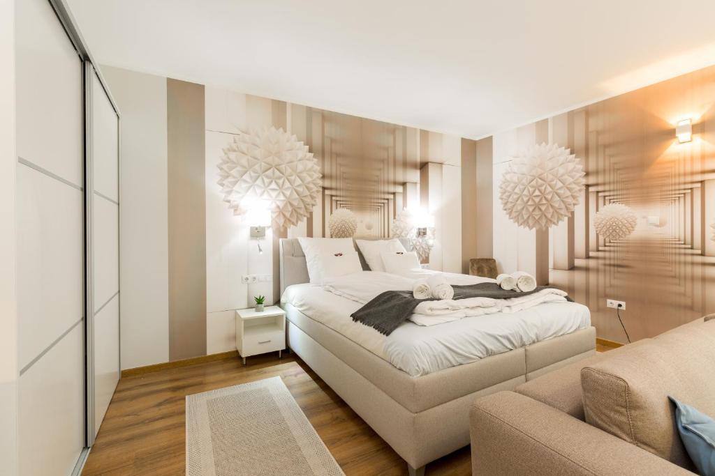 een slaapkamer met een groot bed en een bank bij BUDAPEST DOWNTOWN Residences - AC,ELEVATOR,TERRACE in Boedapest