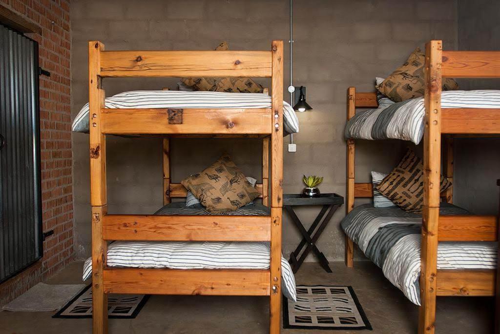 Pokój z 2 drewnianymi łóżkami piętrowymi w pokoju w obiekcie The little Club Getaway at The Hay Barn w mieście Lidgetton