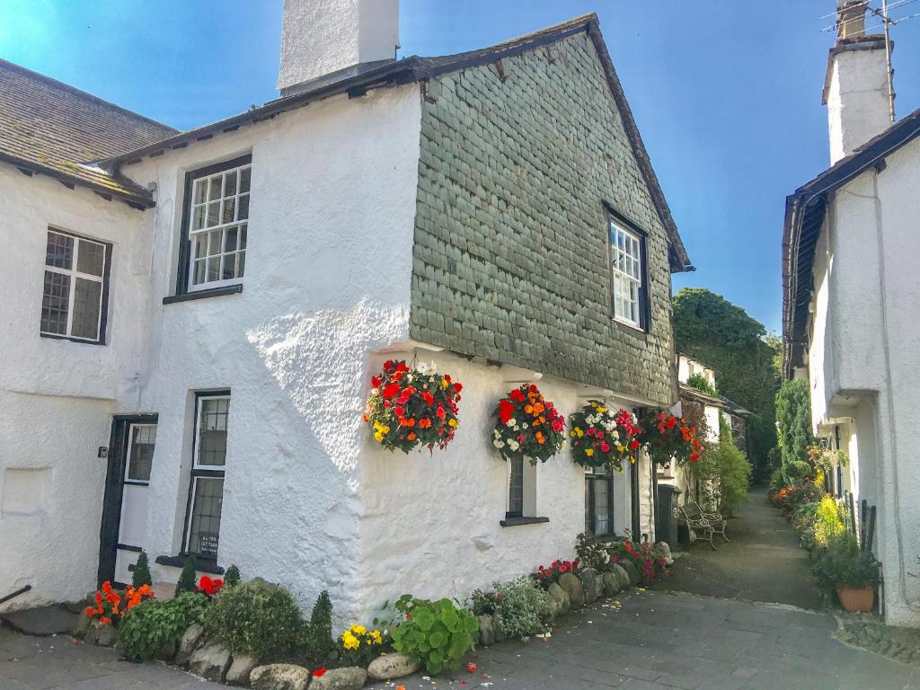 ein weißes Gebäude mit Blumen auf der Seite in der Unterkunft Alice's Cottage in Ambleside