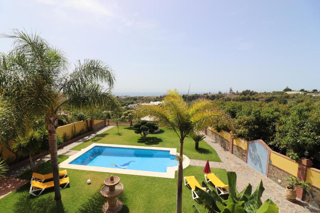 una piscina en un patio con palmeras en Villa AndreaSol SpainSunRentals 1128, en Frigiliana