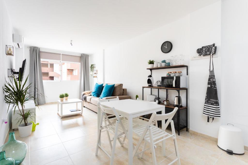 ein weißes Wohnzimmer mit einem Tisch und einem Sofa in der Unterkunft Home2Book Cozy Apartment Puertito, Wifi in Puertito de Güímar