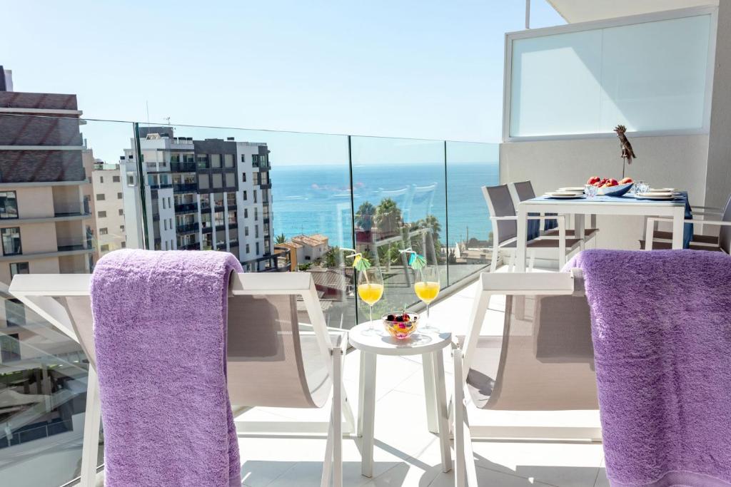 un balcón con 2 sillas y una mesa con copas de vino en Calpe Beach, en Calpe