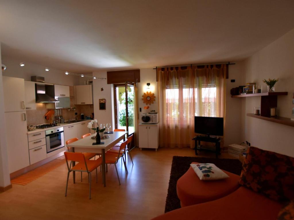 cocina y sala de estar con mesa y sillas en Belvilla by OYO Cherry House, en Mergozzo